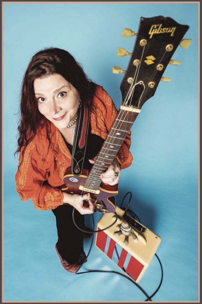 A woman holding an electric guitar in her hands.